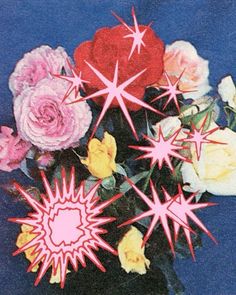 a vase filled with lots of flowers on top of a blue table covered in pink and yellow stars