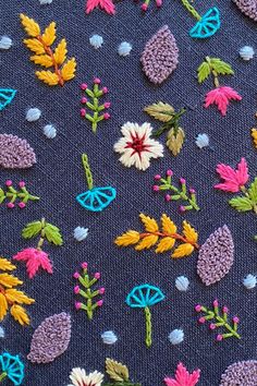 a close up view of some flowers and leaves on a blue cloth with white dots