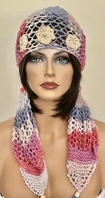 a mannequin wearing a hat with flowers on it's head and scarf around its neck