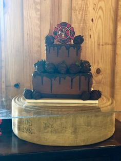 a three tiered chocolate cake sitting on top of a table