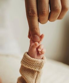 a person holding the finger of another persons hand