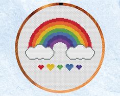 a cross stitch rainbow with hearts on it