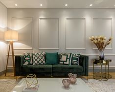 a living room with green couches and decorative items on the coffee table in front of it