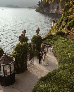 a bride and groom are walking down the stairs to their wedding ceremony at lake comoni