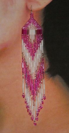 a woman wearing pink and white beaded earrings