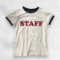 White “Staff” Graphics Tee W/ Navy Blue Lining On Sleeve And Neck Sz Small. Brand New Without Tags White Letter Print Top For Workwear, Cotton Workwear Tops With Logo Print, White Letter Print Top For Work, Sporty Cotton T-shirt For Work, Blue Short Sleeve Slogan T-shirt, Graphics Tee, Blue Relaxed Fit T-shirt With Logo, Blue Cotton T-shirt With Horizontal Stripes, Affordable Blue American Flag Print T-shirt