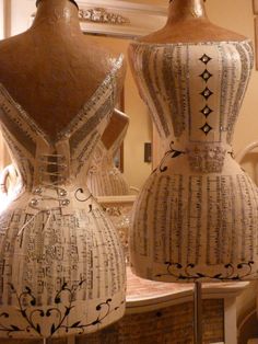 two ceramic vases sitting on top of a table next to each other in front of a mirror