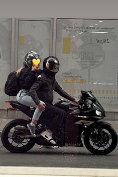 a man and woman riding on the back of a motorcycle