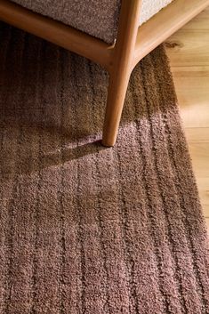 a brown rug on the floor next to a bed