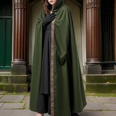 This is a designer image. A majestic, floor-length cloak in a rich, dark green hue, perfect for adding an air of mystery and elegance to any ensemble. The cloak is designed with a generous hood that gracefully frames the face and extends into a full, sweeping cape that offers dramatic flair with every movement. This versatile piece can be seen as ideal for a variety of settings, including fantasy-themed events, renaissance fairs, or as part of a theatrical costume where a regal or mystical chara Deer Person, Cloak Medieval, Steampunk Costumes, Medieval Cloak, Designer Image, Cape Cloak, Long Cape, Larp Costume, Hooded Cloak