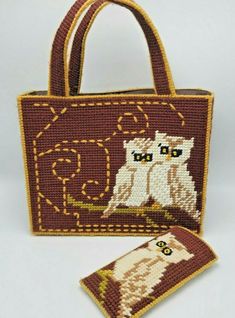 an embroidered purse with two cats on it and a small tag attached to the front