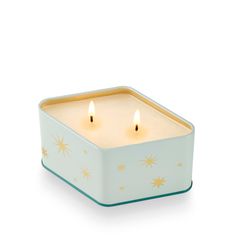 two lit candles in a blue box on a white background with gold stars around the edges