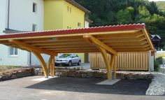 a car parked under a covered parking lot in front of a yellow and white building