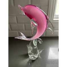 a glass dolphin sculpture sitting on top of a table