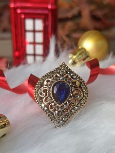 Kosem Sultan Authentic Turkish Style Unique Ring Vintage Ottoman Style Hurrem Sultan Magnificent Century A beautiful and stylish accessory! Authentic and unique Turkish design. Ottoman-style vintage jewelry that will make you feel like real Sultana from Ottoman Dynasty. Named after The Great KOSEM Sultan, the ring is coming only in one unique design combining blue resin & red black crystal stones Dimensions: 33mm Weight: 10.2g Details: resin, crystal, zinc alloy with antique gold plating Elegant Festive Ring With Intricate Design, Elegant Rings For Festive Celebrations, Elegant Festive Rings For Celebration, Elegant Holiday Jewelry For Celebration, Vintage Jewelry For Holiday Parties, Vintage Holiday Jewelry For Party, Vintage Holiday Party Jewelry, Holiday Party Vintage Jewelry, Gold Bohemian Rings For Party