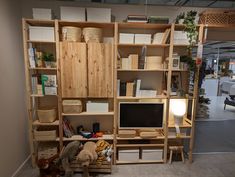 a room with shelves, bookshelves and stuffed animals on the floor in front of it