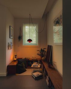 a living room filled with furniture next to a window and a lamp hanging from the ceiling