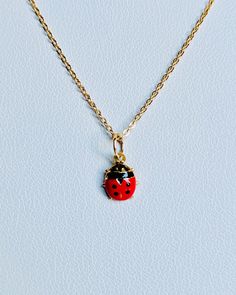 "A beautiful 14K yellow gold Red and Black Lady Bug puffy charm / pendant with hand painted and baked enamel. It has a soldered ring to attach to a bracelet or a necklace. The small pendant measures around 7mm by 6mm. It can be used as a necklace pendant or a bracelet charm and would make a perfect gift. The pendant can be paired with a shiny 14K Yellow Gold 1.2mm cable link chain in either 16\" or 18\" length or with a 16\" 14K gold-plated cable link chain. All items are packaged ready to be gi Handmade Yellow Gold Enamel Necklaces, Handmade Yellow Gold Enamel Necklace, Yellow Gold Enamel Charms For Gift, Handmade Yellow Gold Enamel Jewelry, Dainty Enamel Necklace As A Gift, Yellow Gold Enamel Necklace For Gift, Black Enamel Oval Necklace As Gift, Red Enamel Round Necklace, 14k Gold Necklace With Black Enamel For Gift