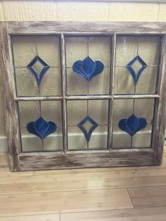 an old window with stained glass hearts on the front and sides, sitting on a wooden floor