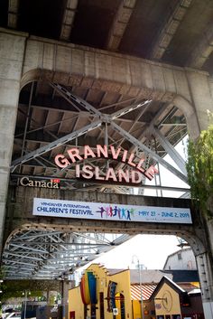 the sign for granville island is hanging from the side of an overpass