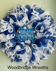 a blue and white wreath with merry christmas written on it