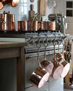 pots and pans are hanging on the rack in this kitchen