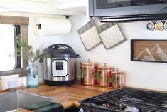 a kitchen counter with an electric pressure cooker next to a stove top oven and microwave