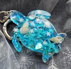 a sea turtle keychain with starfish, shells and seashells on it