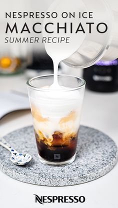 someone pouring something into a glass on top of a table