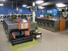 a room filled with furniture and appliances inside of a warehouse like setting that has blue walls