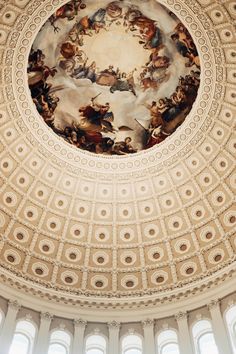 an ornate ceiling with paintings on it in the center of a building's dome