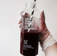 a person holding up a bottle with blood in it that says blood brings taste, guts, plasmas