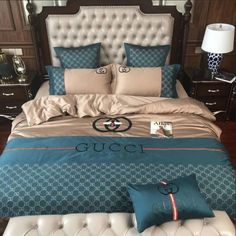 a bed with blue and beige comforters on top of it in front of a wooden headboard