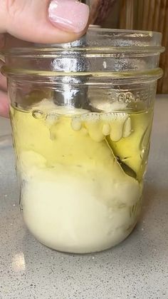 a person is picking up some food in a jar