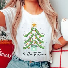 "Spread some holiday cheer in this cute and comfy \"Dentistree\" shirt! This tee is printed DTG (direct to garment) on high-quality Bella + Canvas brand tees. Our soft tees are perfect for wearing on their own and easy to dress up with a cardigan. Made of 100% cotton for solid colors. Heather colors and sports grey include polyester. The shoulders have twill tape for improved durability. The collar is made with ribbed knitting to prevent curling damage. There are no itchy side seams on these t-s Dental Office T Shirt Ideas, Orthodontic Assistant Gifts, Dental Assistant T Shirt Ideas, Cute Dental Shirts, Dental Office Tshirt Ideas, Dental Assistant Tshirts, Dental Christmas Shirt, Dental Halloween Shirt, Dental Office Shirts