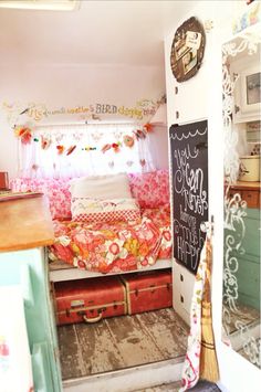 a room with a bed, dresser and chalkboard on the wall next to it