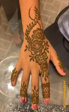 a woman's hand with henna tattoos on it