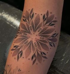 a woman's foot with a flower tattoo on it