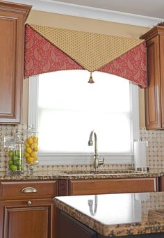 a kitchen window with a red and yellow valance hanging over it