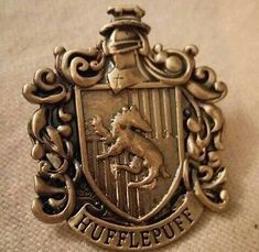 an antique silver plated metal badge with a horse and shield on the front,