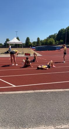 some people laying on the ground in a track