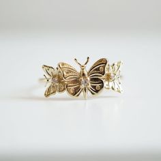 "With brave wings, she flies..."The "Butterfly Hope ring" ring is inspired by the beauty and endurance of butterflies. It symbolizes personal transformation, hope, and rebirth. Three gold butterflies sit on a 14K solid gold band, embellished with your choice of tiny white diamonds. Handcrafted in 14K solid yellow gold, rose gold and white gold. 14K solid gold Natural round white diamonds. SI clarity. Approx 0.035ct 1.2mm ring band **This item is specially made for you. Please allow 1-2 week lead Gold Butterfly Ring In Fine Jewelry Style, Gold Butterfly Charm Ring, Butterfly Charm Ring For Anniversary, Fine Jewelry Yellow Gold Butterfly Ring, Gold Butterfly Ring With Charm, Gold Butterfly Ring With Butterfly Charm, Gold 14k Butterfly Shaped Ring, Gold 14k Butterfly Ring, 14k Gold Butterfly Ring For Anniversary