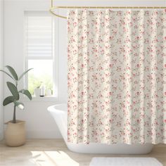 a white bath tub sitting next to a window with a shower curtain in front of it