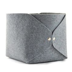 a gray felt box with buttons on the front and side, sitting on a white surface