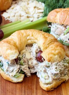 two croissants filled with chicken salad on top of a wooden table