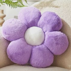 a purple flower pillow sitting on top of a chair