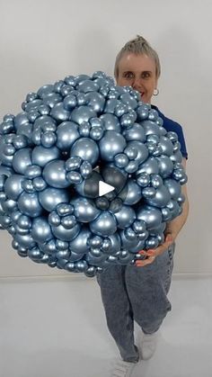 a woman holding a bunch of silver balls