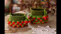 two crocheted baskets sitting on top of a wooden table