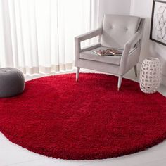 a living room with a chair and red rug