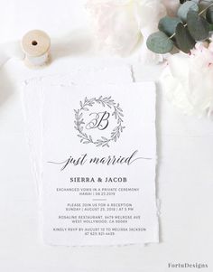 the wedding stationery is laid out next to some flowers